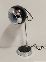 Front view showing orb shade, chrome bezel, base and cord