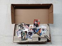 Open cardboard box showing quantity of hockey cards and sample cards displayed on top