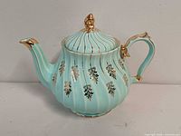 Right side view of teal Sadler teapot showing gold decoration, handle and spout