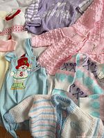 Group view of six knit garments showing colours, patterns and textures