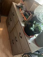 Front and top view of six-drawer dresser with plants on top