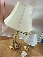 Large brass swing-arm lamp, small brass lamp, book light group view