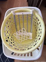 Stacked yellow and white plastic hampers with rack and rings inside