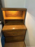 Front view of stacked nightstand showing drawers, shelf and illuminated top section