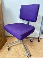 Front three-quarter view showing purple upholstery and armless design