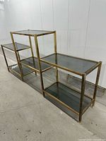 Full view of brass étagère showing stepped tiers and smoked glass shelves