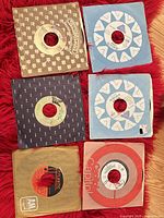 Six 45 rpm records in various company sleeves