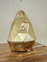 Front view of gold faceted Saje Gem diffuser with cord