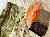 Overview of four scarves laid out on bed