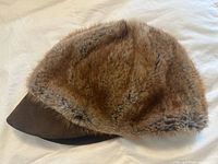 Side view of brown beaver fur cap with suede brim