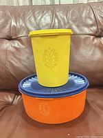 Yellow and orange canisters with lids on sofa