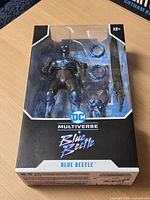 Front view of sealed Blue Beetle figure in box showing figure and accessories