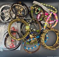 Pile of assorted bracelets displaying styles, colours and materials