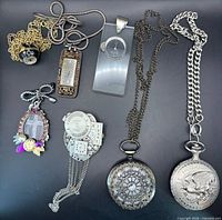 All seven items laid out showing variety of watches, pendant and movements