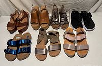 Eight pairs of women’s sandals displayed in two rows