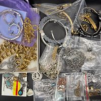 Overview of assorted jewelry pieces in bags and box