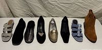 All seven pairs of women’s shoes side by side on table