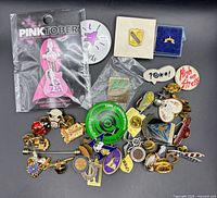 Group shot showing all pins including sealed Pinktober pin and loose assortment