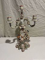 Front view showing four candle sockets, floral arms, figural base