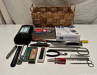 Overall view: basket, lock pick case, matchbooks, harmonica boxes, assorted tools laid out