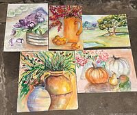 Front view of five unframed watercolor paintings