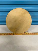 Front view of rawhide drum showing hide head and overall size reference ruler