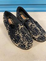 Top view of both slippers showing floral pattern and overall condition