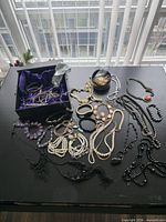 Overview of all jewelry items laid out on table including storage box