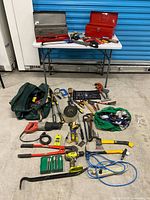Wide shot showing entire lot with toolboxes on table and assorted tools on floor