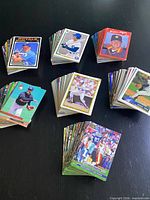 Stacks of assorted baseball and football cards displayed on table