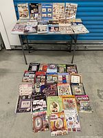 Overall lot – books and magazines laid out on table and floor