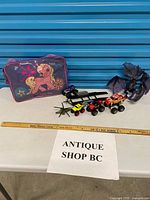 Group shot of all toys including My Little Pony case, dragon, helicopter, monster trucks, trailer