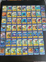 Overall layout showing entire set of roughly 60 Digimon cards arranged in grid