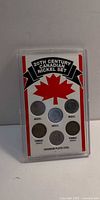 Front view of plastic case showing six Canadian nickels with maple leaf graphic