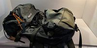 Front view of olive drab hiking backpack showing main compartments and logo patch