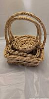 Three nested wicker baskets with visible handles