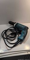 Full view of Makita corded hammer drill with coiled cord