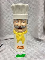 Front view of ceramic chef canister showing facial details and hat lid