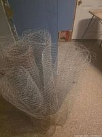 Five rolled sections of chicken wire standing upright