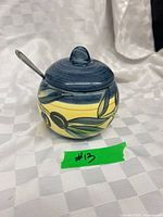 overall view of round ceramic condiment jar with lid and spoon