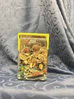 Front view of jar showing densely packed jewelry pieces