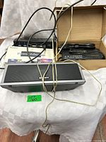 Front view showing Sony speaker, Kimaru box, Ethernet switch, and AC adapter in cardboard