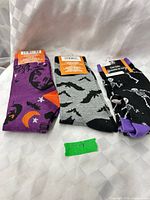 Three pairs Halloween socks laid flat showing designs and tags