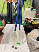 Both paddles upright showing shafts and blades, drip rings at base