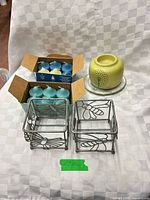 Group shot showing candles in boxes, ceramic warmer on glass base, and two metal holders