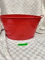 Full view of red oval metal pail front and side handles