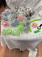 Sealed disc cases with green silicone straws and bag of black phone grips