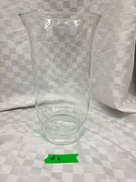 Full view of clear glass vase against white fabric backdrop