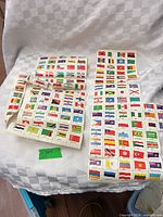 Three folded sheets of flag stamps on checkered cloth