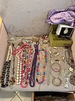 Overview of necklaces, bracelets, brooches, sunglasses, watch box and sleep mask